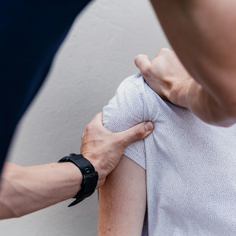 Therapist treating a patient's shoulder at a health and wellness clinic